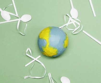 Illustration of Earth's environment impacted by plastic waste on a green background.