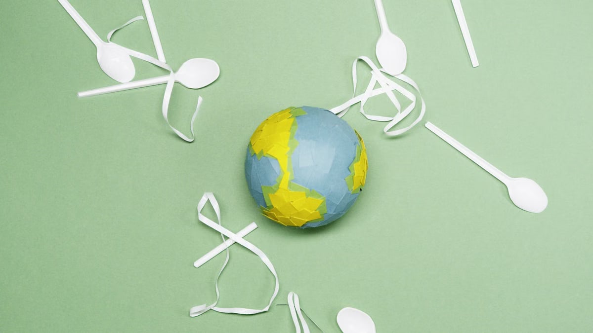 Illustration of Earth's environment impacted by plastic waste on a green background.