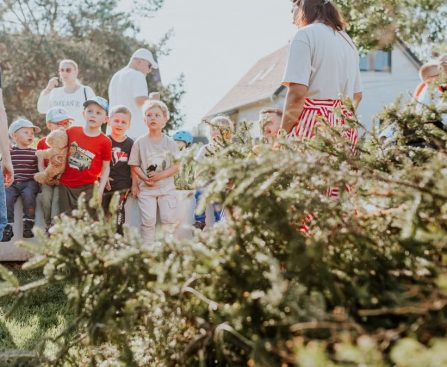Children and adults participating in an outdoor educational activity surrounded by nature.